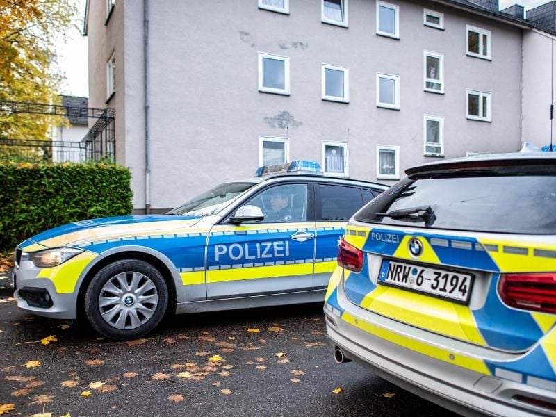 Polizeifahrzeuge vor dem Mehrfamilienhaus in Detmold, in dem eine 15-Jährige ihren dreijährigen Halbbruder erstochen haben soll. Foto: Guido Kirchner/dpa