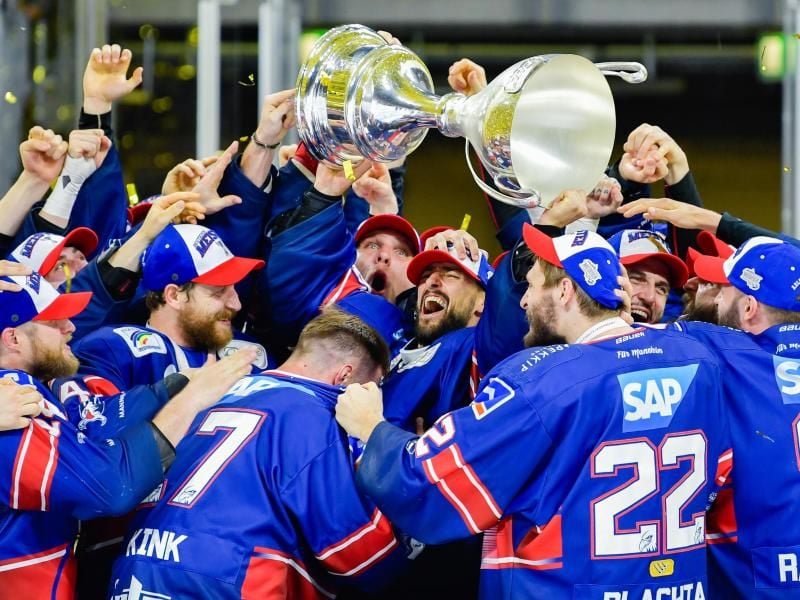 Die Adler Mannheim um Torhüter Dennis Endras (M.) feiern den Gewinn der deutschen Meisterschaft. Foto: Uwe Anspach