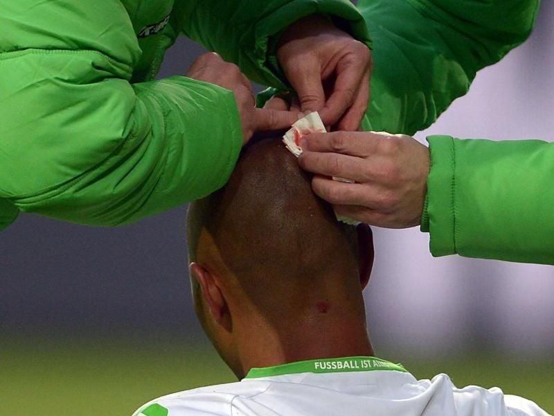 Ein Spieler wird am Hinterkopf verarztet. Künftig werden die Fußballprofis nach Kopfverletzungen gezielt auf Hirnschädigungen untersucht. Foto: Peter Steffen