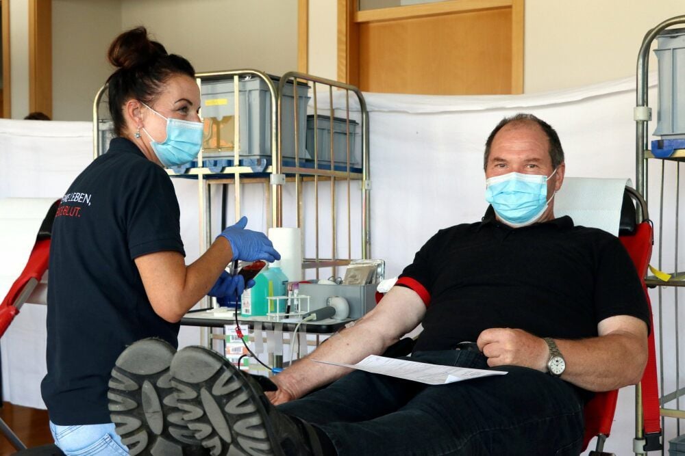 Jana Peter vom Blutspendedienst bereitet den Spender Klaus-Gunther Seyffert für die Blutentnahme vor.