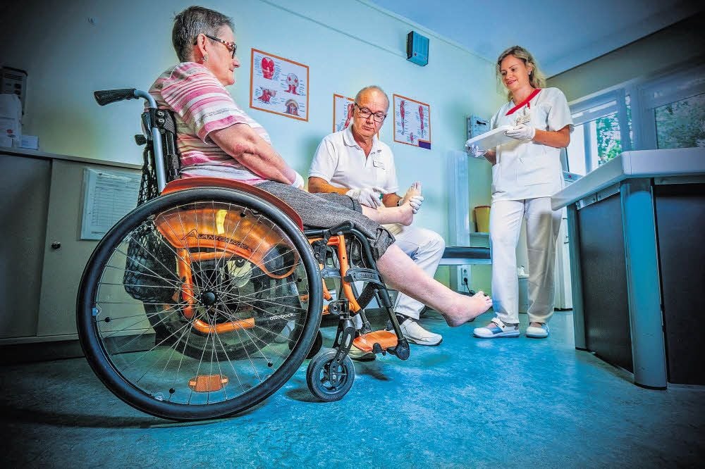 Chefarzt Dr. Frank Hoffmann verabreicht seiner Patientin Simone Schlesier Botulinumtoxin-Spritzen gegen Spasmen im Bein. Schwester Sarah Hochfeld assistiert ihm.