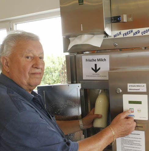 Der Röblinger Kuno Sonnenkalb zapft Milch an dem Automaten auf dem Obsthof.