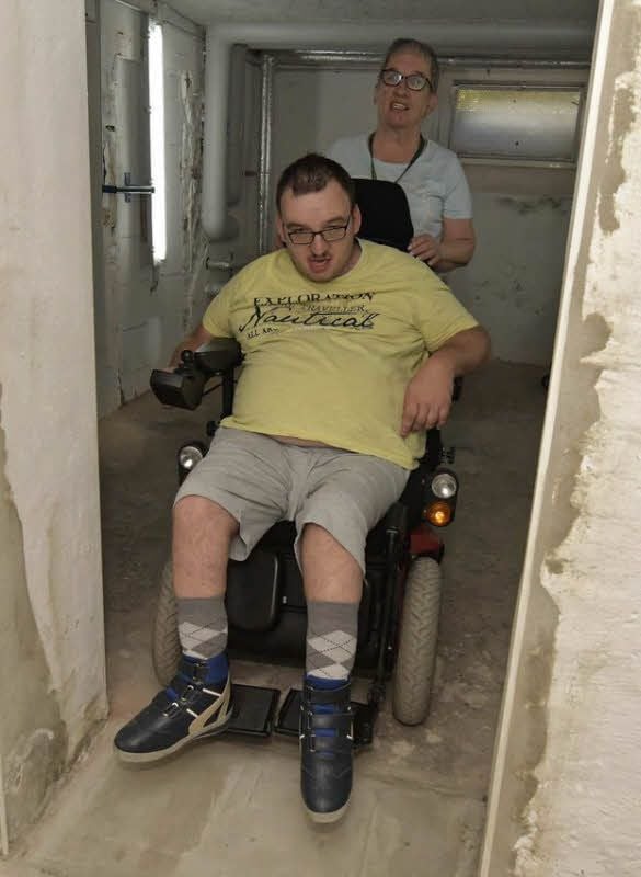 In einem Kellerraum wird der Rollstuhl geparkt, steigt Florian Liszkowski auf seinen Wohnungsrollstuhl um. Doch wenn er nach draußen will, muss er durch winklige Gänge zum Fahrstuhl. Das fällt ihm mit seinem Ersatzrollstuhl sehr schwer. Seine Mutter hofft deshalb auf eine schnelle Reparatur.