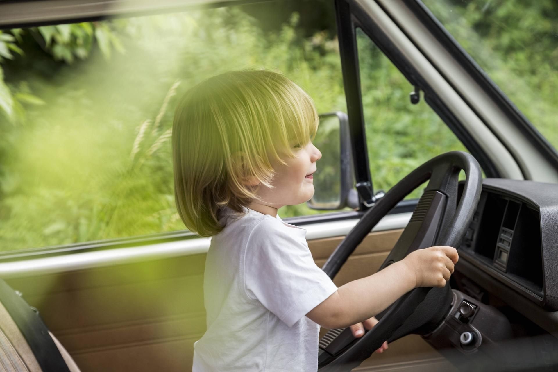 Ein Kind sitzt auf dem Fahrersitz eines Autos (Symbolfoto).