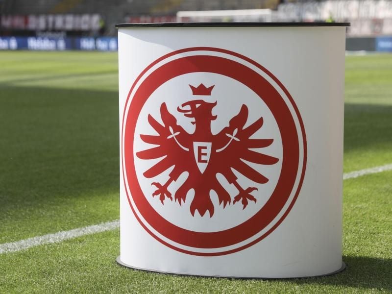 Das Logo von Eintracht Frakfurt auf einem Pult. Foto: Frank Rumpenhorst/dpa/Archivbild