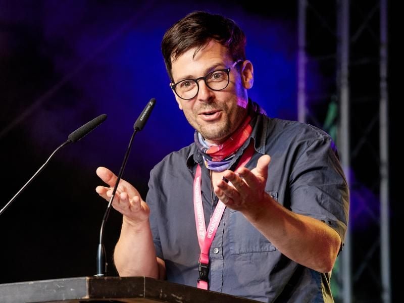 Andras Siebold spricht während der Eröffnung des Sommerfestivals auf Kampnagel. Foto: Georg Wendt/dpa