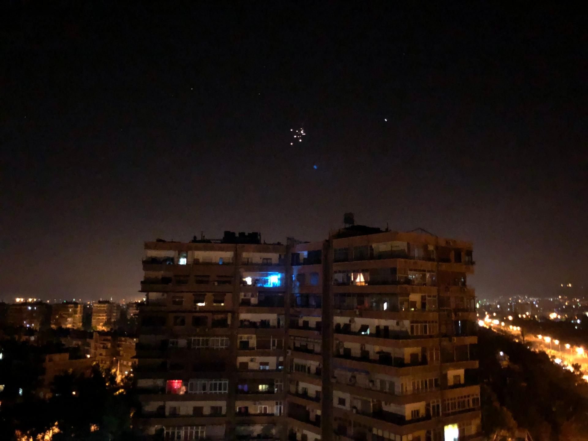 Syrische Luftabwehrraketen fliegen im Himmel über der Stadt.