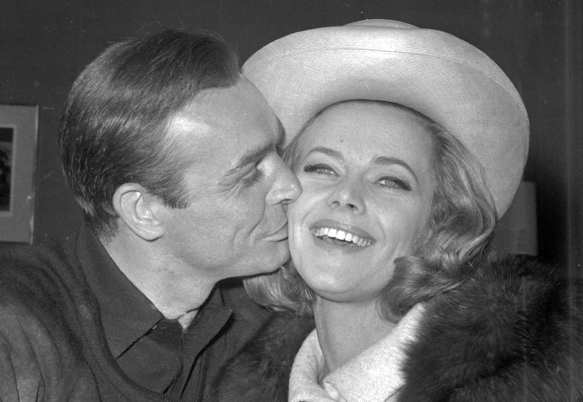 Der britische Schauspieler Sean Connery gibt seiner Kollegin Honor Blackman einen Kuss auf die Wange.