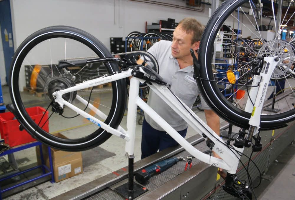 Sachsenring-Mitarbeiter Peter Fuhrmann bei der Montage eines E-Bikes für die Firma Leon Cycle aus Hannover.