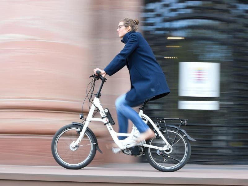 Eine Mitarbeiterin im hessischen Ministerium für Verkehr und Landesentwicklung, fährt auf einem Pedelec. Foto: Arne Dedert/Archiv