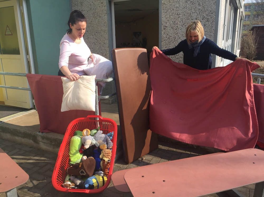 Anja Kratze (l.) und Jeannette Seidler hinter der Kita: Gardinen, Matratzen oder Spielzeug wurden dem Frost ausgesetzt, um mögliche Milben zu töten.