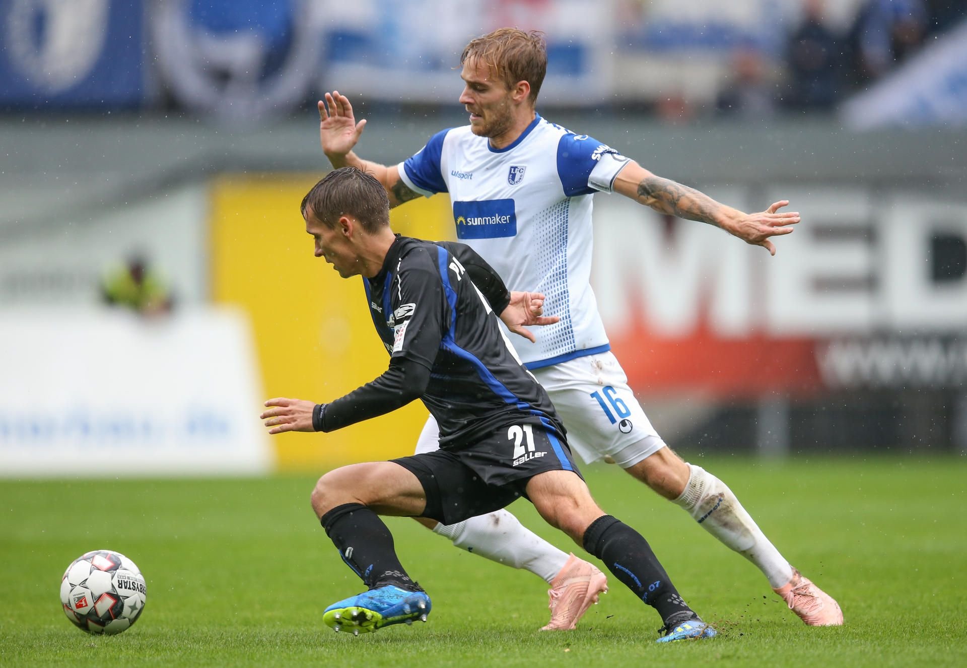 Philipp Klement (l) im Kampf um den Ball mit Nils Butzen (r) aus Magdeburg.