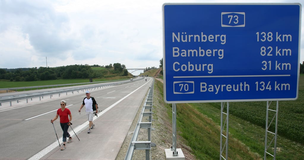 Spaziergänger laufen am Freitag (25.07.2008) über die Bundesautobahn A 73 bei Schleusingen. Das letzte Teilstück der Thüringer-Wald-Autobahn im Freisstaat Thüringen zwischen Schleusingen und Eisfeld-Nord wird am gleichen Tag zurerst für Radler und Fußgänger und am Abend für den Verkehr freigegeben. Die A 73 von Lichtenfels (Bayern) nach Suhl ist zusammen mit der A 71 von Schweinfurt über Suhl nach Erfurt Teil des Verkehrsprojektes Deutsche Einheit. In Bayern wird mit der Fertigstellung des letzten Abschnittes zwischen Ebersdorf bei Coburg und Lichtenfels im September gerechnet. Die A 71 wurde bereits im Dezember 2005 für den Verkehr freigegeben. Für den Bau der beiden Autobahnen einschließlich der wichtigsten Zubringerstraßen wurden 820 Millionen Euro ausgegeben, davon rund 345 Millionen Euro für die A 73. Foto: Martin Schutt dpa/lth/lby (zu lby 7061 vom 25.07.2008) +++ dpa-Bildfunk +++