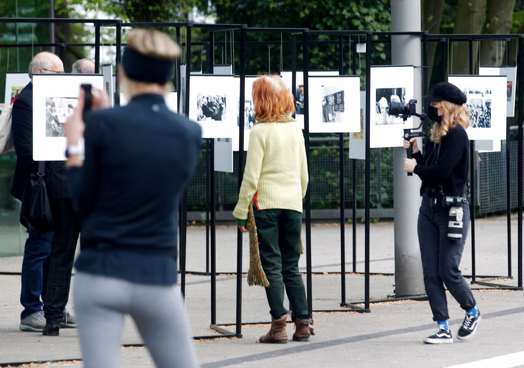 Spaziergänger schauen sich die Outdoor-Fotoausstellung im Rahmen der Ruhrfestspiele am Festspielhaus an.