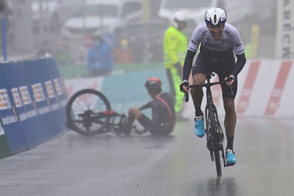 Michael Woods überquert als Etappensieger die Ziellinie. Im Hintergrund liegt der gestürzte Geraint Thomas am Boden.