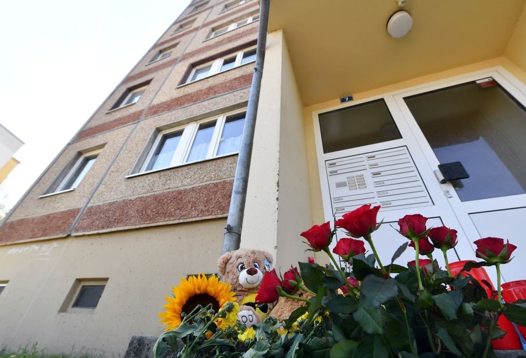 In Gedenken an ein Kleinkind aus Querfurt liegen Blumen und Kerzen vor dem Wohnhaus. Der zweijährige Junge war am 11.07.2020 in einer Wohnung des Hauses mit massiven Verletzungen und Spuren schweren sexuellen Missbrauchs tot aufgefunden worden.