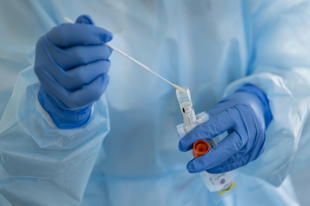 Eine Krankenschwester mit dem Nasenabstrich eines Patienten.