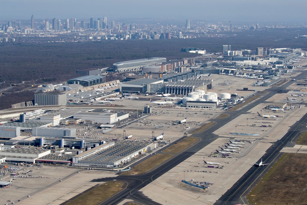 Blick über den Flughafen mit der Skyline der Innenstadt im Hintergrund.