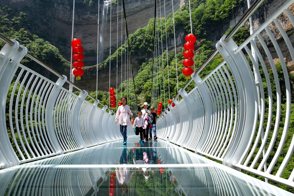 Touristen über eine Glasbrücke im Bezirk Zigui. Der Vorfall, bei dem ein Mann aus 100 Metern Höhe gerettet werden musste, heizt die Diskussion über die Sicherheit solcher Skywalks an.