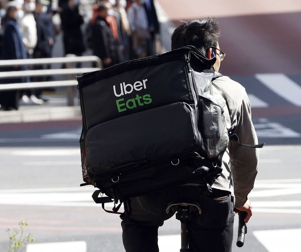 Ein Mitarbeiter des Essenslieferdienstes Uber Eats radelt mit einer Lieferung durch die Stadt.
