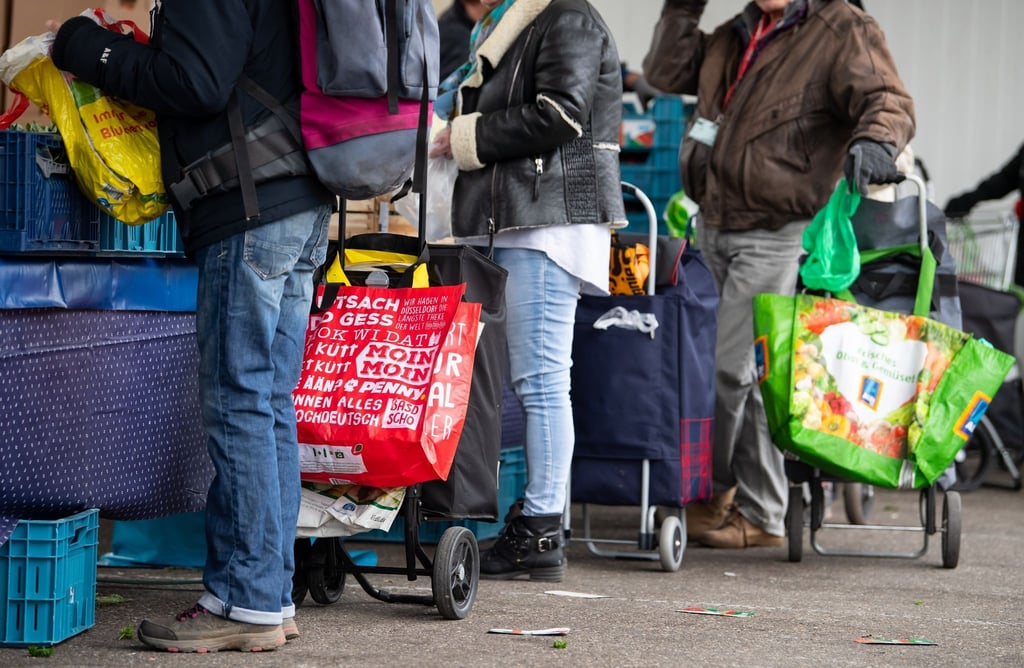 Gäste der Münchner Tafel stehen an der Ausgabestelle am Großmarkt in München.