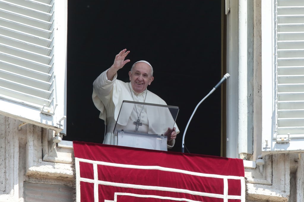 Papst Franziskus winkt vom Fenster mit Blick auf den Petersplatz.