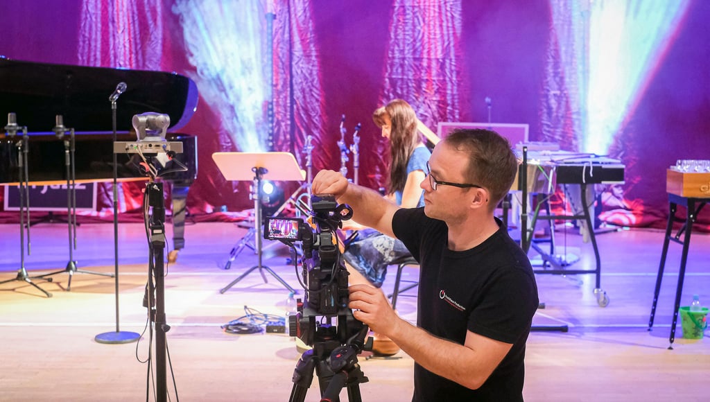 Techniker Christoph Behling bringt eine der Kameras für den Live-Stream in Position. Im Hintergrund spielt sich Jazzerin Izabella Effenberg ein.