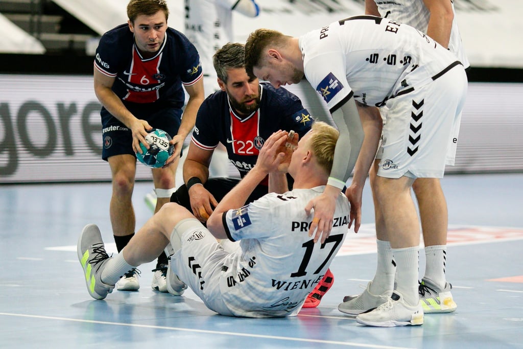 Die Pariser Spieler Luc Steins (l-r) und Luka Karabatic und Kiels Niclas Ekberg (r) kümmern sich um den verletzten Patrick Wiencek.