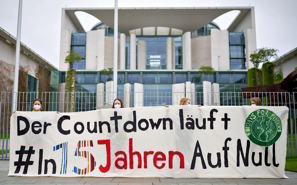 Umweltaktivisten zeigen bei einer Demonstration für mehr Klimaschutz vor dem Bundeskanzleramt ein Transparent mit der Kernforderung.