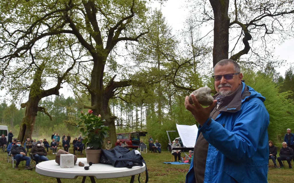 Missionar Jens Schulz von der Evangeliumsgemeinschaft Mittlerer Osten zeigt beim Freiluftgottesdienst im Wald bei Emden einen Kalkstein, den er von der Insel Rügen mitgebracht hatte.