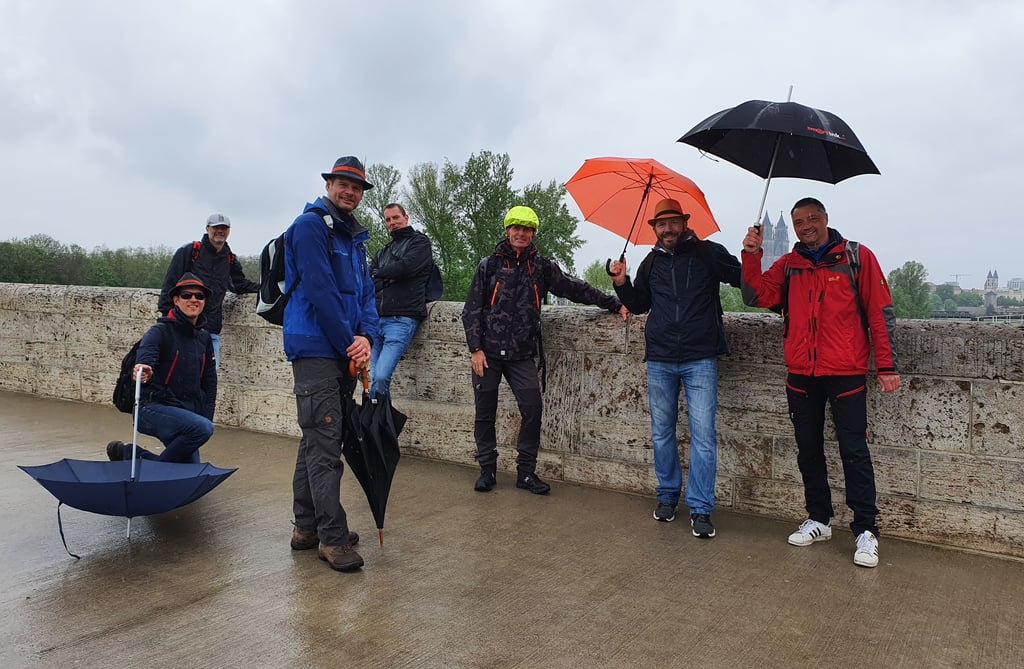 Diesen Männern ist das Wetter egal. Mit Schirmen ziehen sie am Herrentag durch Magdeburg. Für ein Foto rutschen sie ausnahmsweise kurz ein wenig zusammen.
