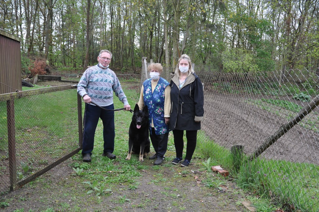 Helmut und Beate Fürbaß, Tochter Betty Westermann und Schäferhund Rex an ihrer Grundstücksgrenze in Parchen. Dahinter beginnt der Wald. Foto: Susanne Christmann