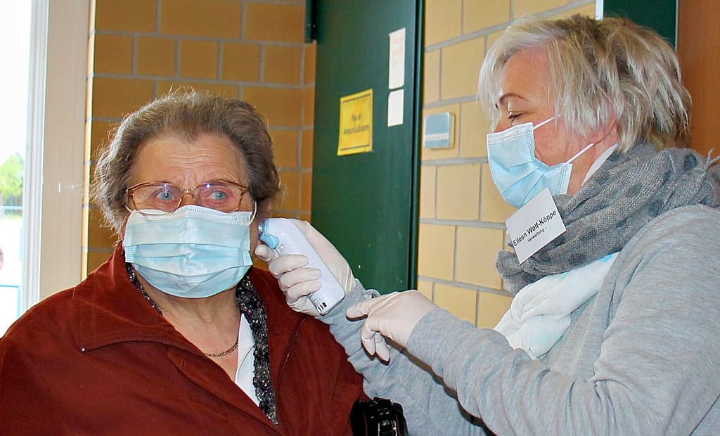 Jugenclubleiterin Eileen Wolf-Köppe misst bei Christa Adler aus Schleuß die Temperatur.