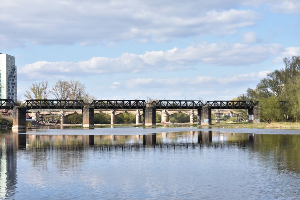 Im Vordergrund die denkmalgeschützte Kanonenbahnbrücke über die Alte Elbe in Magdeburg. Dahinter zeichnet sich die Anna-Ebert-Brücke ab. 