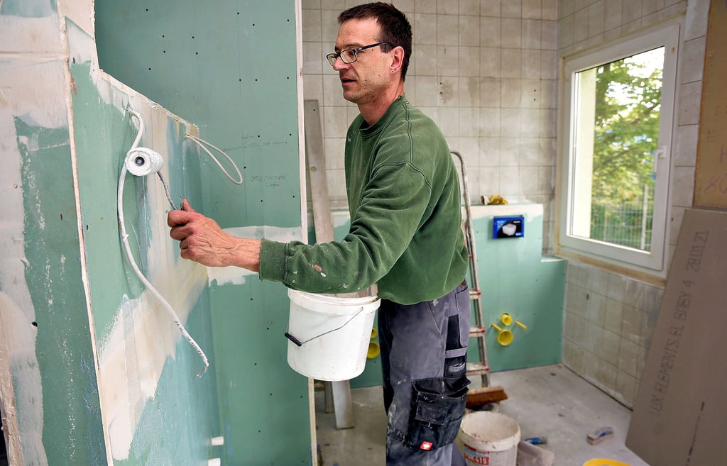 In der Kita „Sonnenschein" werden die Toilettenräume saniert. Ingo Hamm von der Firma Fliesen Schubert aus Dessau grundiert hier die Wände.