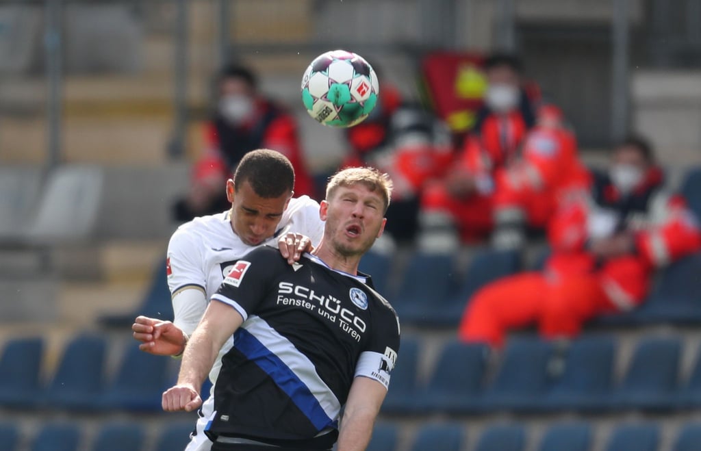 Bielefelds Fabian Klos (vorne) im Kopfballduell mit Hoffenheims Kevin Akpoguma.