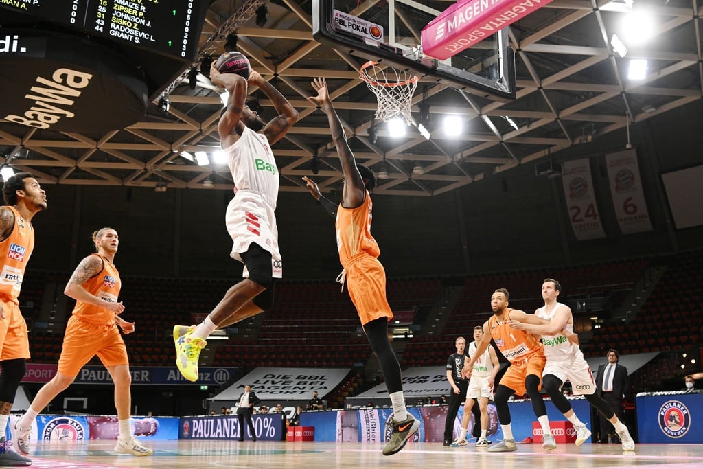 Bayerns Jalen Reynolds (l) zieht gegen Ulms Aric Holman zum Korb.