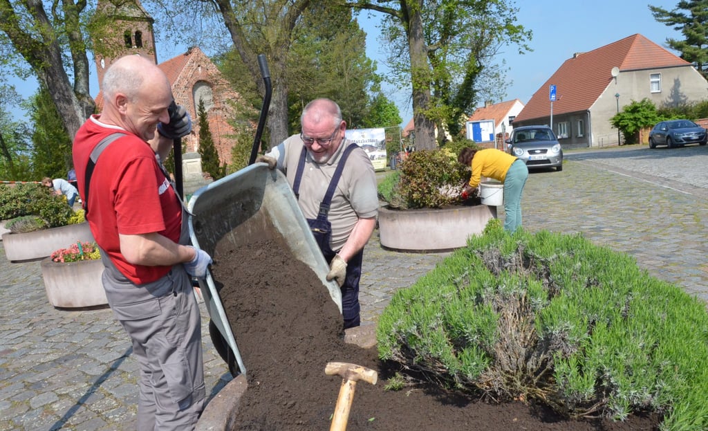 Thomas Tornow und Harald Bauherr befüllen die Kübel mit Erde.