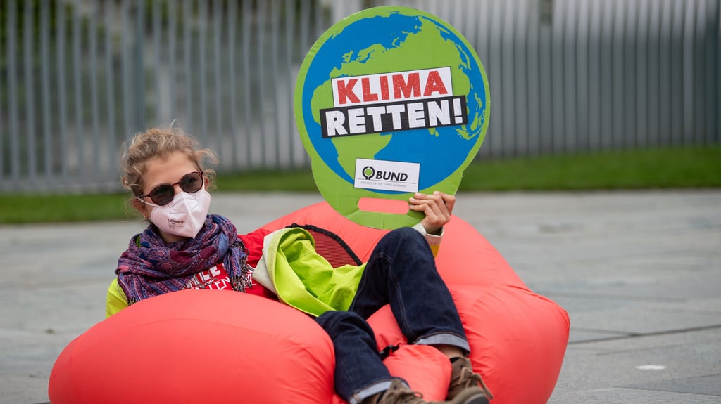 Eine Umweltaktivistin hält bei einer Demonstration für mehr Klimaschutz vor dem Bundeskanzleramt ein Plakat mit der Aufschrift "Klima retten!". Junge Ostdeutsche seien einer Umfrage zufolge unzufrieden mit bisheriger Klimapolitik.