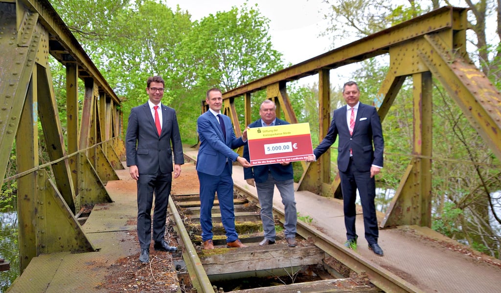 Die Vertreter der Sparkassen-Stiftung Steffen Brichovsky (l.) und Markus Latz (r.) überreichen an der Bodebrücke den Scheck an Verbandsgemeindebürgermeister Fabian Stankewitz (2.v.l.) und Gröningens Bürgermeister Ernst Brunner.