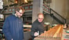 Orgelbauer Michael Wetzel (rechts) zeigt Domkantor Matthias Bensch an einem der restaurierten Wellenbretter, wie die kleinen Ärmchen, die er zum Teil rekonstruiert hat, befestigt werden.  