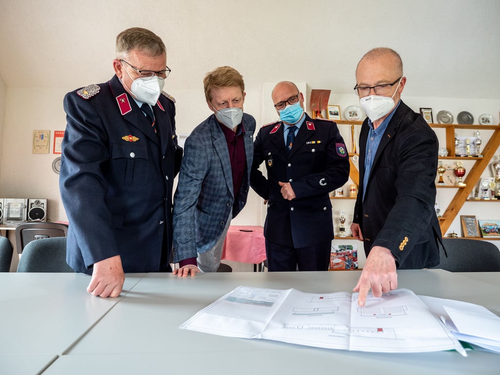 Barbys Stadtwehrleiter Detlef August (v.l.), Gemeindebürgermeister Torsten Reinharz, Zuchaus Ortswehrleiter Mike Mikoleit und Bauamtsleiter Holger Goldschmidt begutachten den Bauplan des neuen Feuerwehrgerätehauses Zuchau.