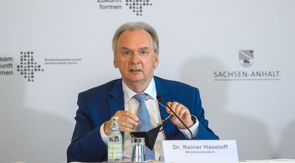 Reiner Haseloff (CDU), Ministerpräsident des Landes Sachsen-Anhalt, sitzt in der Staatskanzlei am Podium einer Pressekonferenz.