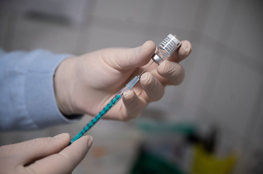 Ein Arzt zieht in einer Hausarztpraxis eine Spritze mit dem Impfstoff von Pfizer/Biontech auf.