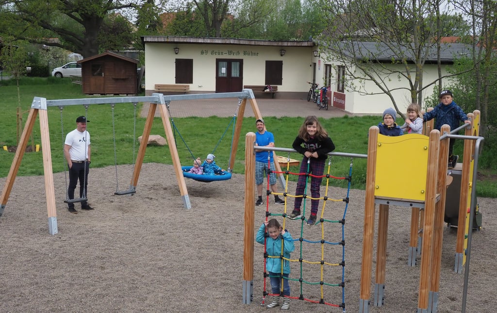 Im Grünen neben Bühnes Sportlerheim steht der neue Spielplatz, den die Eltern für die Kinder gebaut haben. Ein kleines Paradies zum Klettern, Schaukeln und Wippen. im Hintergrund freuen sich die Väter Matthias Michler (links) und Florian Brasche mit dem Nachwuchs über das gelungene Werk.