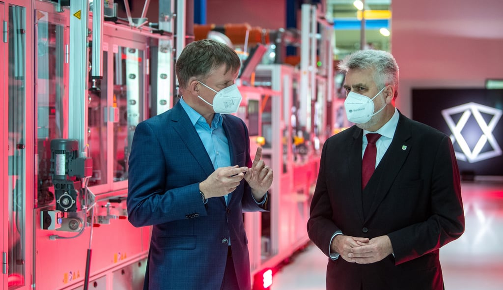 Gunter Erfurt (l), CEO von Meyer Burger, und Armin Willingmann (SPD), Wirtschaftsminister von Sachsen-Anhalt, stehen am Eingang zur Produktion von Solarzellen des Schweizer Unternehmens Meyer Burger.