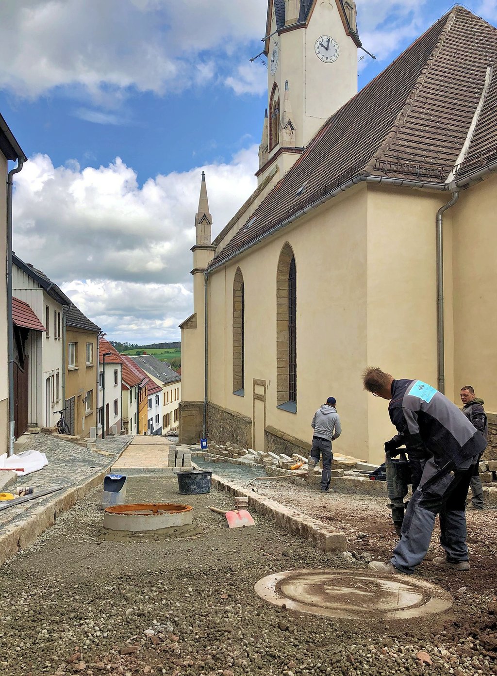 Bei den Bauarbeiten am Kirchberg in Osterfeld hinter der Kirche ist Handarbeit gefragt.