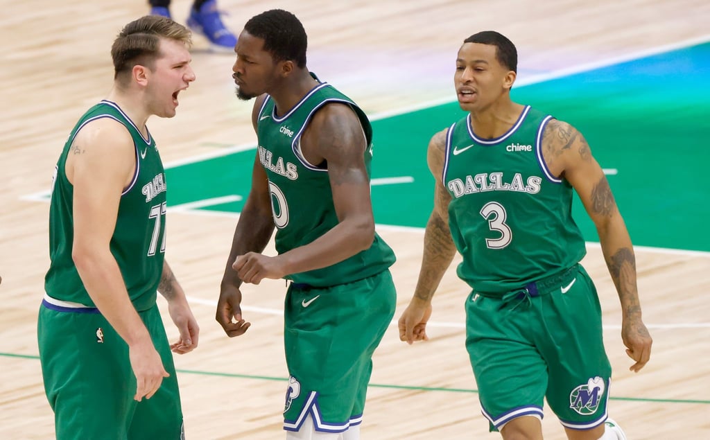 Luka Doncic (l-r) von den Dallas Mavericks jubelt mit seinen Teamkollegen Dorian Finney-Smith und Trey Burke.