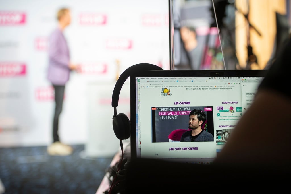 Ein Zuschauer des Festivals folgt einem Interview mit den Geschäftsführern auf der Bühne.