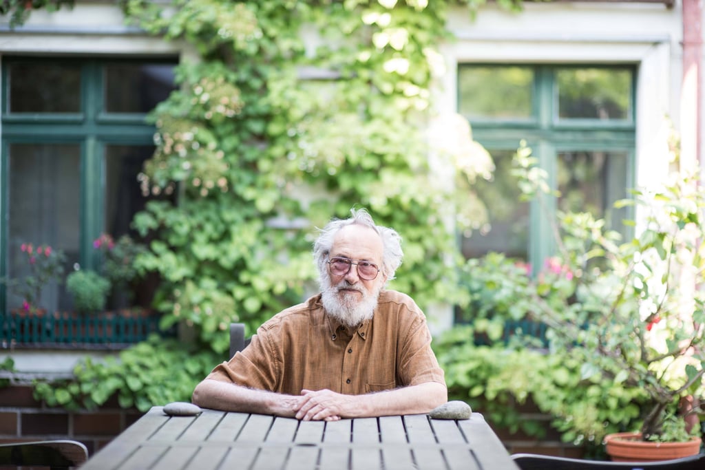 Harald Kretzschmar, Karikaturist und Zeichner, sitzt an einem warmen Sommertag entspannt in einem Gartenstuhl.
